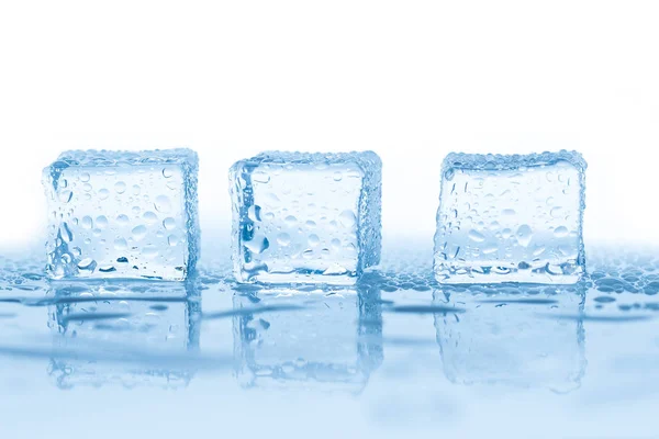 Cubos de gelo quadrados com gotas de água limpa no banner de fundo azul — Fotografia de Stock