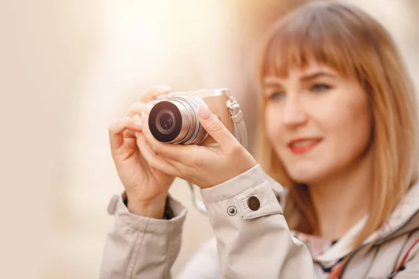 Portrét šťastný cestovatel fotograf dívka drží malou kameru v ruce, rozmazané pozadí — Stock fotografie
