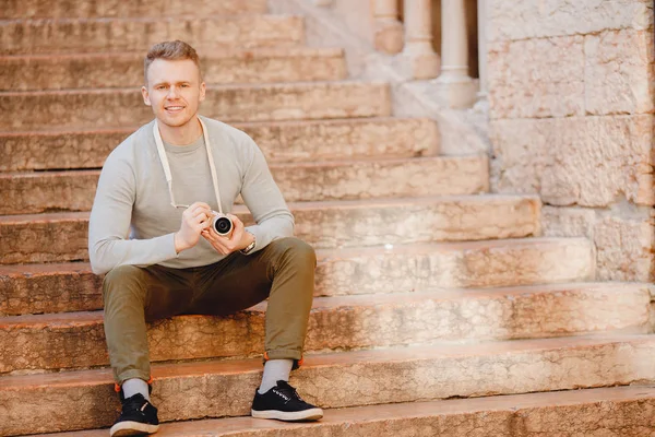 손에 소형 카메라를 들고 있는 남자 여행자 사진사는 기기의 정확성 과가벼움에 놀랐다 — 스톡 사진
