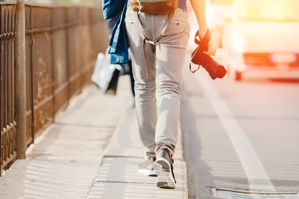 Vue arrière, voyageur avec sac à dos et appareil photo marche le long de la route du rêve, photographe indépendant — Photo