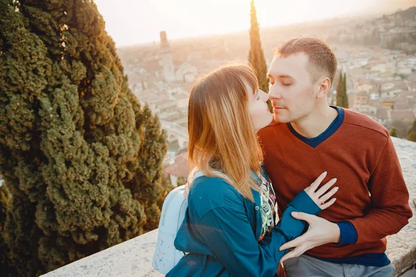 Romantische Paar Mann und Mädchen umarmen und küssen sich auf Sonnenuntergang Hintergrund der Stadt Verona Italien. Reisekonzept — Stockfoto