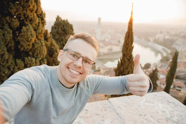 Happy άνθρωπος ταξιδιώτη λήψη selfie φωτογραφία στο φόντο της πόλης Βερόνα Ιταλία ηλιοβασίλεμα. Ταξιδιωτική έννοια — Φωτογραφία Αρχείου