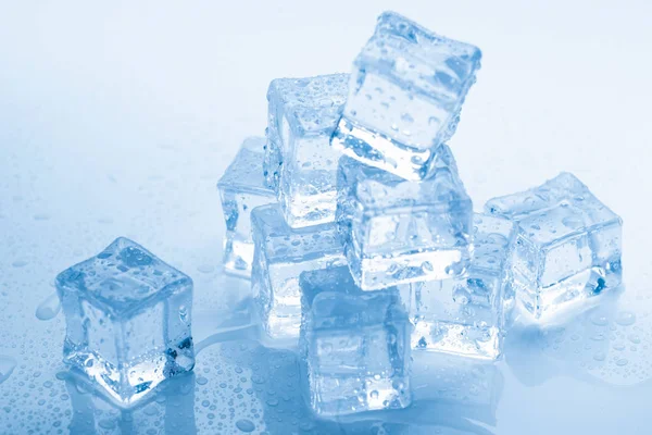 Ice cubes square with drops water clean on blue background