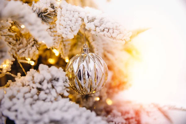 Kerstboom achtergrond met kunstmatige sneeuw versierd speelgoed ballen, tak gouden verlichting — Stockfoto