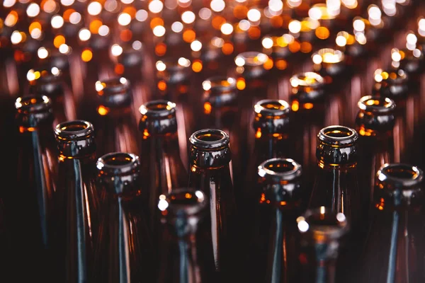 Стеклянные бутылки пива на темном фоне. Линия производства пивоваренного завода — стоковое фото