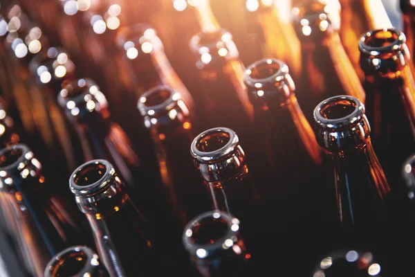 Крупный план открытые коричневые стеклянные темные бутылки для пива спирт, блики линзы — стоковое фото