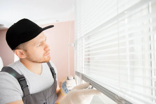 L'operaio edile installa tende su finestre upvc bianche di plastica in casa — Foto Stock