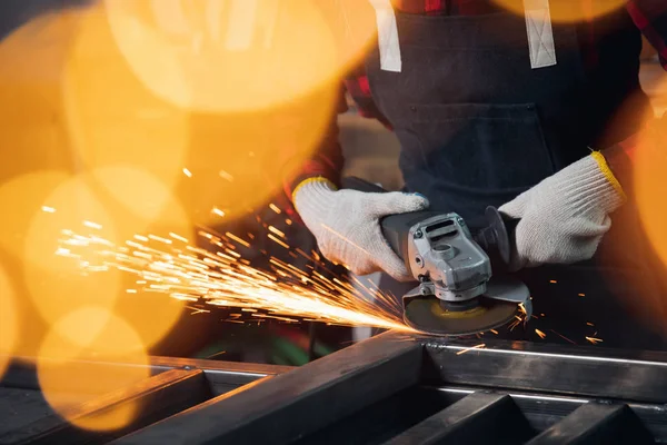 Mano de trabajador sierra eléctrica rueda de molienda en la estructura de acero en fábrica, chispa ligera —  Fotos de Stock