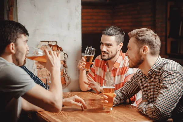 Beber cerveza artesanal de vasos en el pub, grupo de amigos varones. Concepto noche después del trabajo encuentro amistad — Foto de Stock