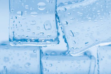 Buz küpleri kare mavi zemin üzerinde temiz su damlaları ile