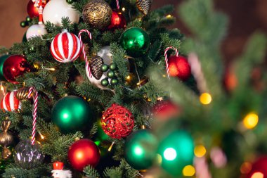 Noel arkaplan ağacı süslemeleri ile şeker kamışı kırmızı ve yeşil toplar, bokeh ışıklı