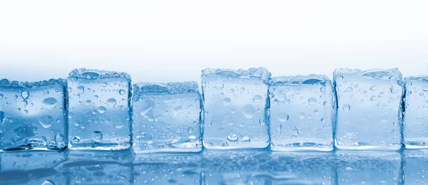 Cubos de hielo cuadrados con gotas de agua limpia sobre el banner de fondo azul — Foto de Stock