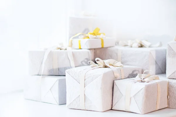 Bílé vánoční dárky se stříbrnou stuhou luk, sluneční svit — Stock fotografie