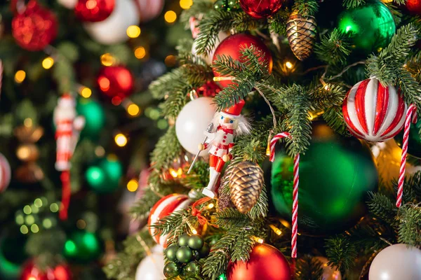 Rama de árbol de fondo de Navidad con decoraciones caramelo piruleta bastón rojo y verde bolas, con luz bokeh — Foto de Stock