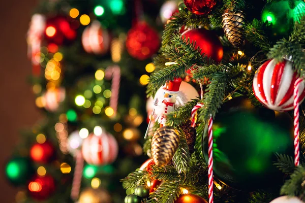 Weihnachten Hintergrund Baum Zweig mit Dekorationen Zuckerlutscher rote und grüne Kugeln, mit Bokeh-Licht — Stockfoto