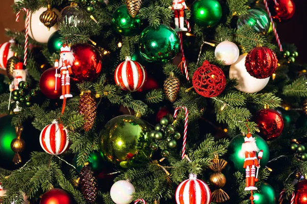 Geschmückter Weihnachtsbaum rote und grüne Farbe, Nahaufnahme von Spielzeug und Dekor gestreifte Süßigkeiten — Stockfoto