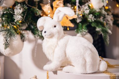 Noel ağacının arka planında beyaz yapay tavşan tavşanları