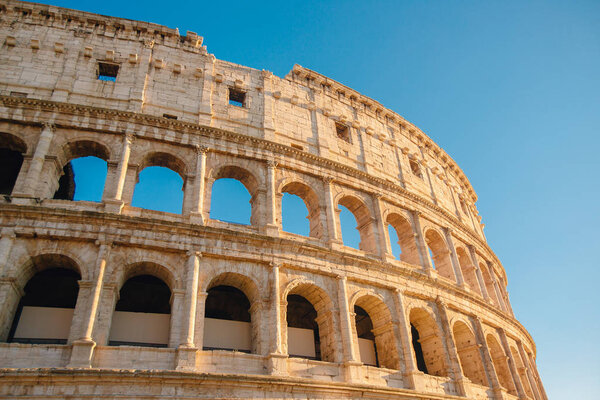 Colosseum or Coliseum ancient ruins background blue sky Rome, Italy.