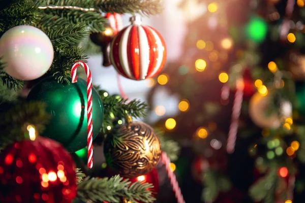 Rama de árbol de fondo de Navidad con decoraciones caramelo piruleta bastón rojo y verde bolas, con luz bokeh — Foto de Stock