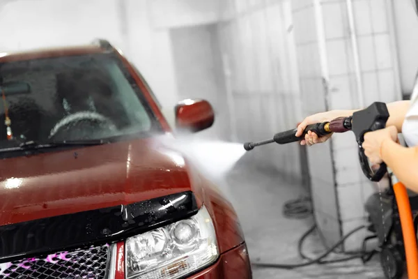 Arbeiter wäscht Auto mit Hochdruckwasser — Stockfoto