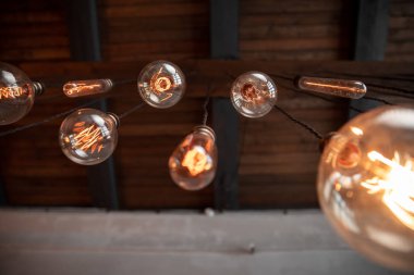 Edison lambası çatı katında, beton duvarın arka planında.
