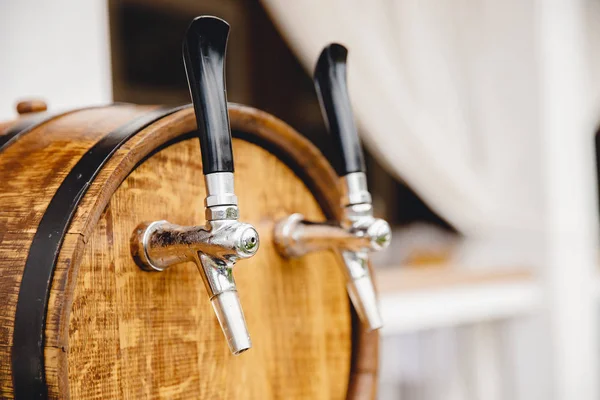 Wooden keg with taps for beer pouring drink into mugs bar, summer parties