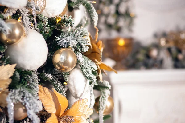 Διακοσμημένο χριστουγεννιάτικο δέντρο λευκό και χρυσό χρώμα, γκρο πλαν των παιχνιδιών και διακόσμηση, τζάκι στο παρασκήνιο — Φωτογραφία Αρχείου