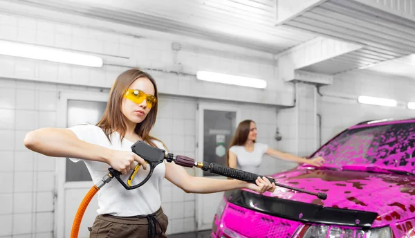 Autoservis detailní mytí, dvě krásné ženy čisté auto s vodou pod tlakem — Stock fotografie
