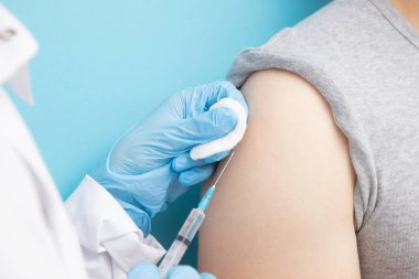 Hemşire, insana Corona virüsü enjekte etmeye karşı aşı veriyor. Salgını durdurma kavramı