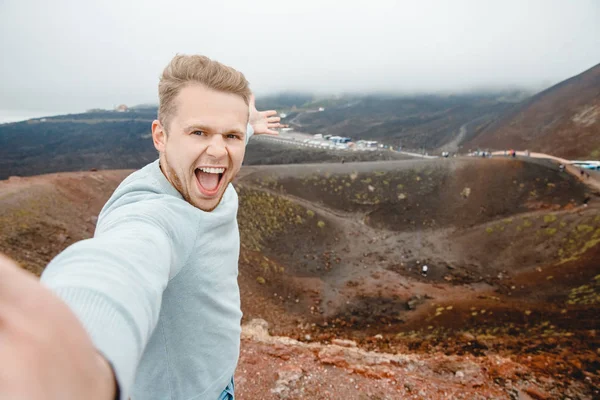 Etna vulkaan, Sicilië Italië, man reiziger met rugzak maakt selfie foto op de achtergrond van bergen in as — Stockfoto