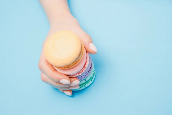 Menina de mão de beleza com unhas de manicure na moda tomando macaroons de cor. Conceito cuidados com a pele, flat lay — Fotografia de Stock