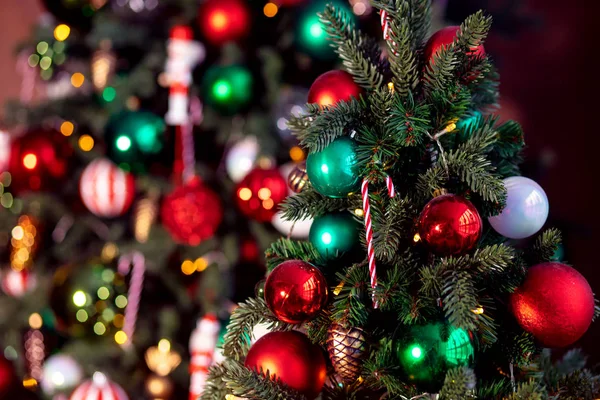 Kerst achtergrond boom tak met decoraties snoep lolly stok rood en groen ballen, met bokeh licht — Stockfoto