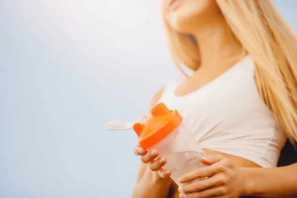 Schöne Blondine trinkt nach dem Training im Park Wasser aus Sportflasche — Stockfoto