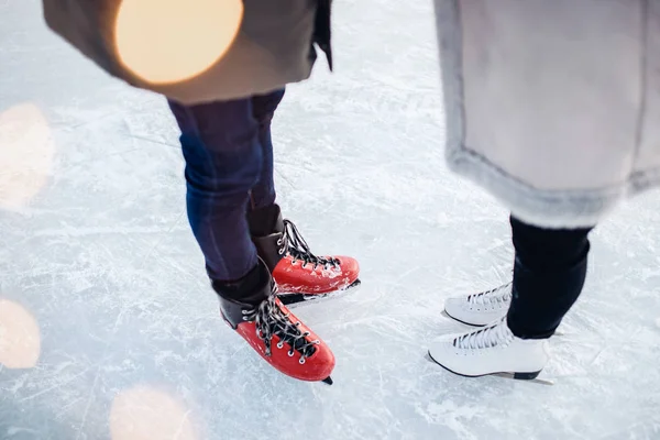 Patins cara e menina para andar na pista de gelo no inverno, fundo bokeh, vista superior — Fotografia de Stock