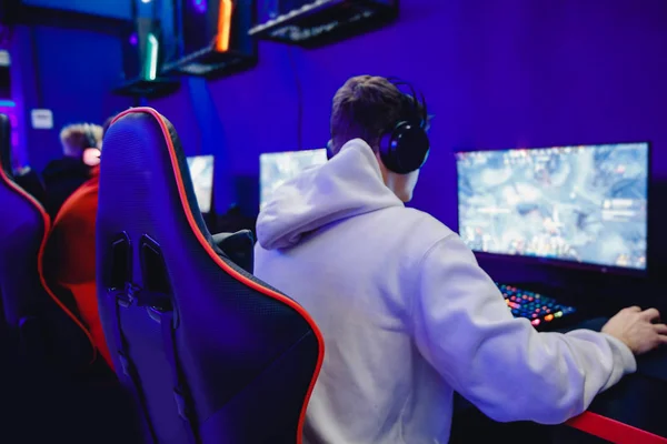 Jugador profesional jugando torneos online videojuegos ordenador con auriculares, rojo y azul — Foto de Stock