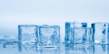 Buz küpleri kare mavi zemin üzerinde temiz su damlaları ile