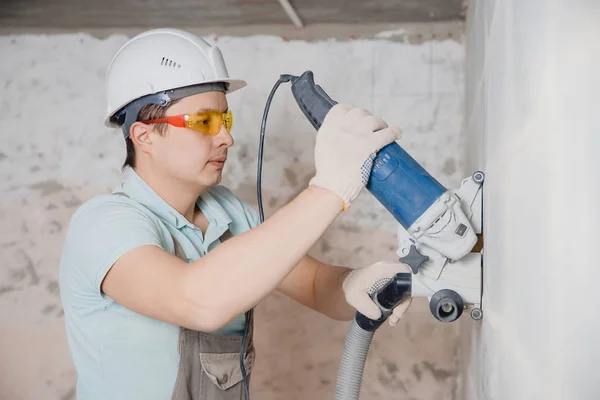 Builder worker cutting electrical chase in concrete wall with circulation saw drill diamond crown — Stock Photo, Image