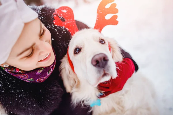 Šťastná mladá žena objímá psa zlatého retrívra v zimním dni. Koncept přátelství — Stock fotografie