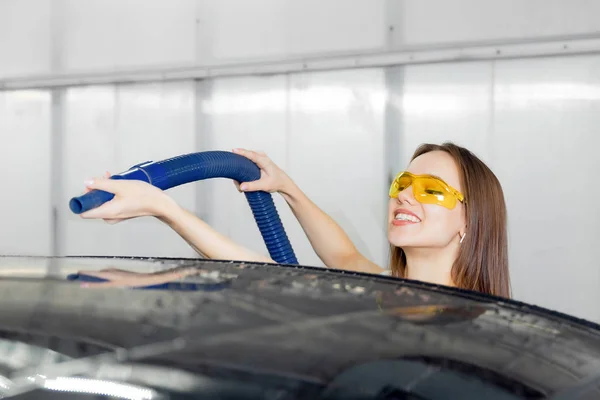 Servicio de lavado de autos express. Chica trabajador utiliza turbo secador para eliminar las gotas de agua —  Fotos de Stock