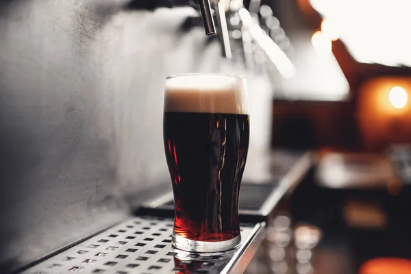 Light Draft koud bier giet in glas van kraan in pub — Stockfoto