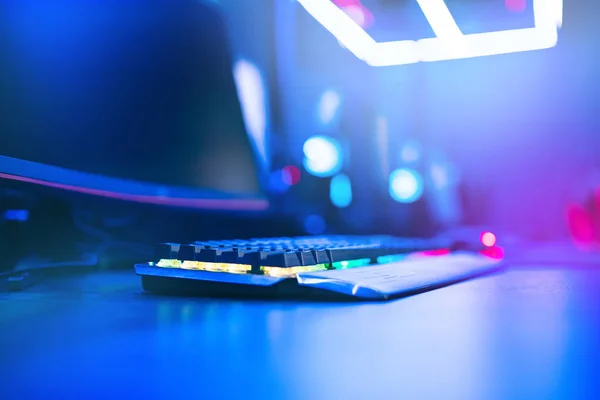 Blurred background computer, keyboard, blue and red lights. Concept eSports arena for gamer playing tournaments — Stock Photo, Image