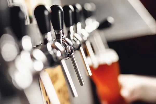 Birra leggera con grande schiuma in vetro sullo sfondo del barista mano — Foto Stock