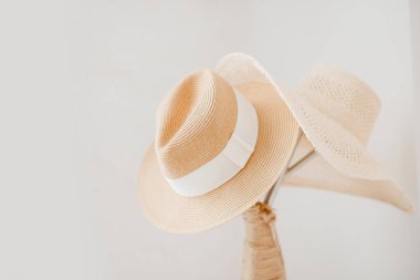 Beyaz ahşap bir askıda asılı saman sarı şapka, İskandinav tarzı minimalizm. Seyahat kavramı