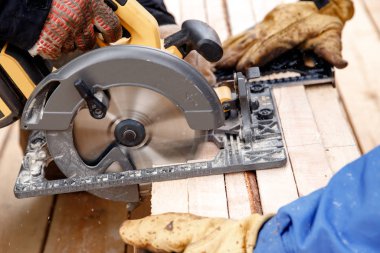 Yapıcı ahşap kesmek için taşınabilir dairesel testere aracı kullanıyor