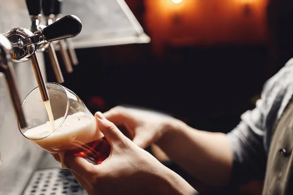 Closeup hand barman donker ambachtelijk koud bier giet in glas van kraan in pub — Stockfoto