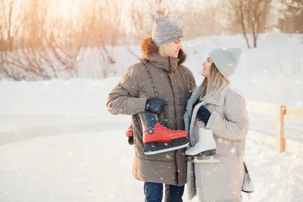 Férias de Natal, jovem e bela menina segurar patins para pista de gelo no inverno, casal amante — Fotografia de Stock