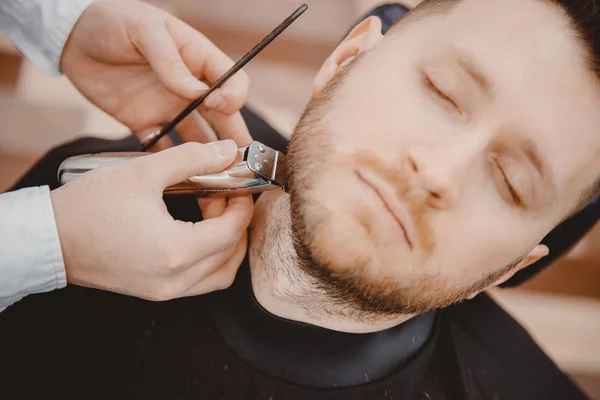 Hipster klient muž návštěvě v holičství holení vousy, Ročník tónované hnědé — Stock fotografie