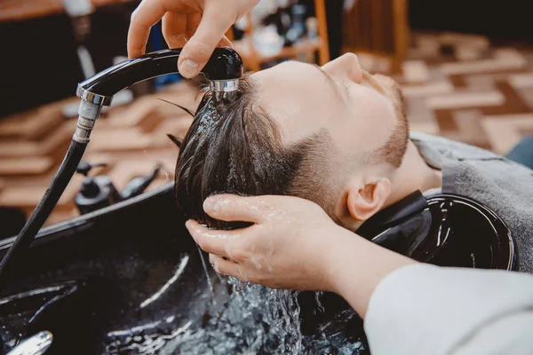 Lavando cabellera peluquería, peluquero enjuaga el champú con la presión del agua — Foto de Stock