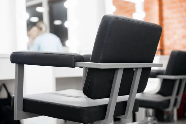 Černá židle pro klienta, rozmazané pozadí kosmetický salon, mistr make-up umělec pracoviště — Stock fotografie