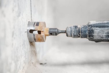 İnşaatçı işçi pnömatik çekiç delme delikleri beton tuğla duvar ve elektrik kablosu için elmas taç, soket, anahtar